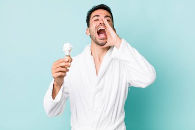 Genç, İspanyol asıllı bir adam kendini mutlu hissediyor, elleri ağızının yanında bağırıyor. traş konsepti