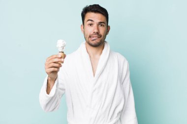 young adult hispanic man looking puzzled and confused. shaving concept