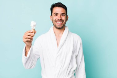 young adult hispanic man looking happy and pleasantly surprised. shaving concept