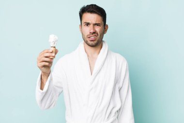 young adult hispanic man feeling puzzled and confused. shaving concept