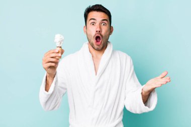 young adult hispanic man feeling extremely shocked and surprised. shaving concept