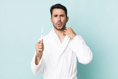 young adult hispanic man feeling stressed, anxious, tired and frustrated. toothbrush concept