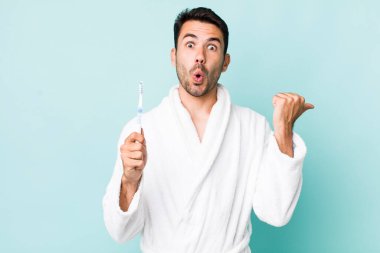 young adult hispanic man looking astonished in disbelief. toothbrush concept