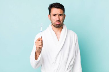 young adult hispanic man feeling sad and whiney with an unhappy look and crying. toothbrush concept