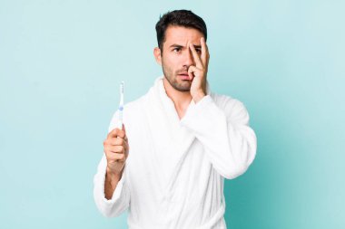 young adult hispanic man feeling bored, frustrated and sleepy after a tiresome. toothbrush concept