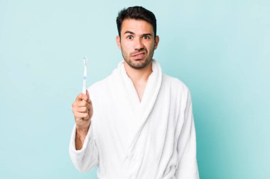 young adult hispanic man feeling puzzled and confused. toothbrush concept