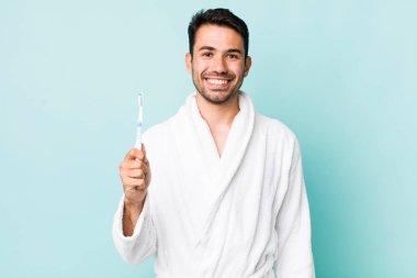 young adult hispanic man looking happy and pleasantly surprised. toothbrush concept