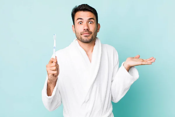 Young Adult Hispanic Man Feeling Puzzled Confused Doubting Toothbrush Concept — Stock fotografie