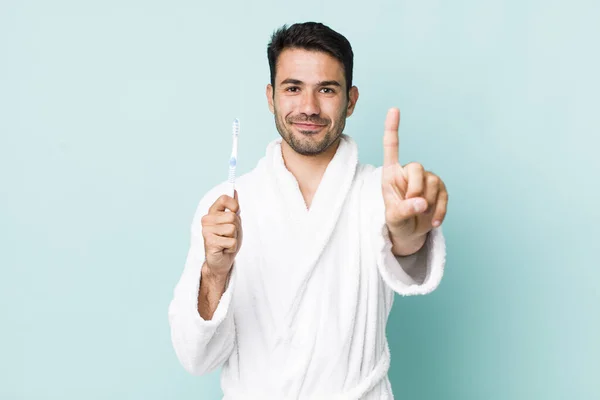 Young Adult Hispanic Man Smiling Looking Friendly Showing Number One — Stok fotoğraf