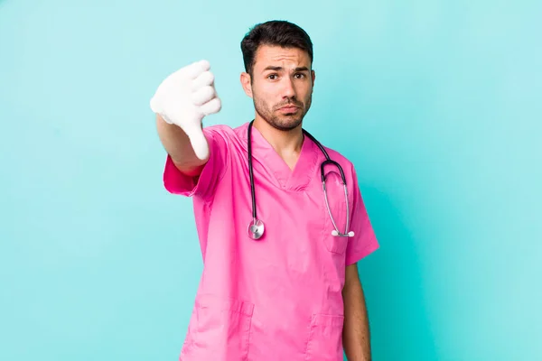 Young Adult Hispanic Man Feeling Cross Showing Thumbs Veterinarian Concept — Stockfoto