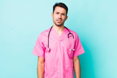 young adult hispanic man feeling puzzled and confused. veterinarian concept