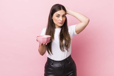 young pretty woman feeling stressed, anxious or scared, with hands on head. empty bowl concept