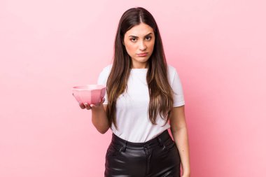 young pretty woman feeling sad, upset or angry and looking to the side. empty bowl concept