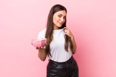 young pretty woman looking arrogant, successful, positive and proud. empty bowl concept