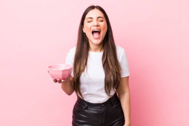 young pretty woman shouting aggressively, looking very angry. empty bowl concept