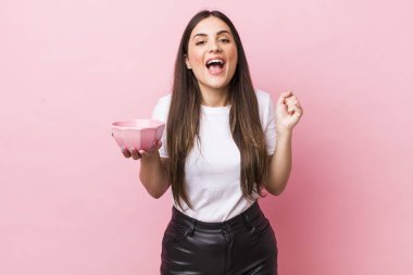 young pretty woman shouting aggressively with an angry expression. empty bowl concept