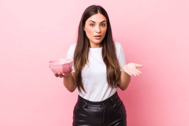 young pretty woman feeling extremely shocked and surprised. empty bowl concept