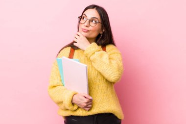 young pretty woman thinking, feeling doubtful and confused. university student concept