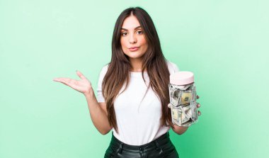 Genç ve güzel bir kadın şaşırmış ve şok olmuş görünüyor. Çenesi düşmüş ve elinde bir nesne tutuyor. kaydetme kavramı