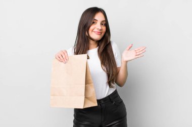 young pretty woman feeling puzzled and confused and doubting. take away food concept