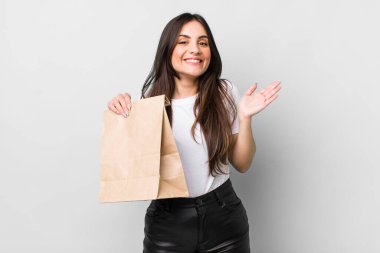 young pretty woman feeling happy and astonished at something unbelievable. take away food concept