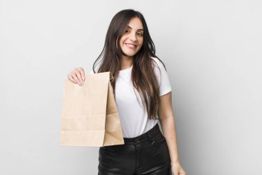 young pretty woman looking happy and pleasantly surprised. take away food concept