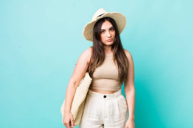 young pretty woman feeling sad, upset or angry and looking to the side. summer and hat concept