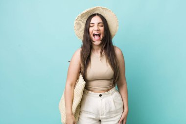 young pretty woman shouting aggressively, looking very angry. summer and hat concept