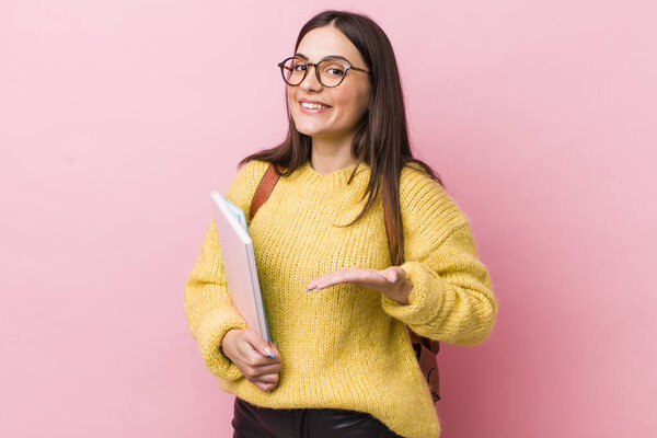 young pretty woman smiling cheerfully, feeling happy and showing a concept. university student concept