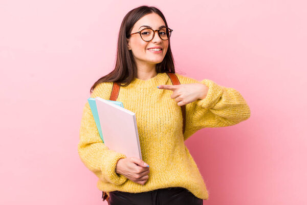 young pretty woman looking excited and surprised pointing to the side. university student concept