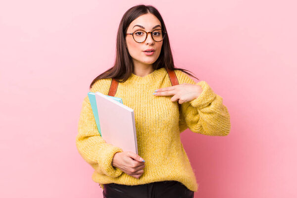 young pretty woman looking shocked and surprised with mouth wide open, pointing to self. university student concept