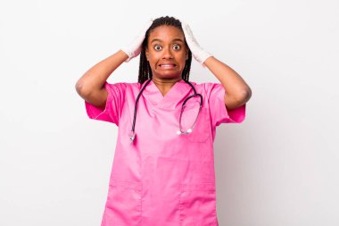 young adult black woman feeling stressed, anxious or scared, with hands on head. veterinarian concept
