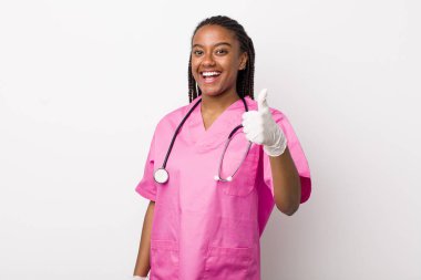 young adult black woman feeling proud,smiling positively with thumbs up. veterinarian concept