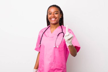 young adult black woman smiling proudly and confidently making number one. veterinarian concept