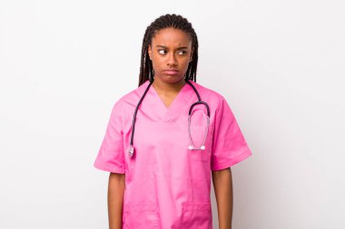 young adult black woman feeling sad, upset or angry and looking to the side. veterinarian concept