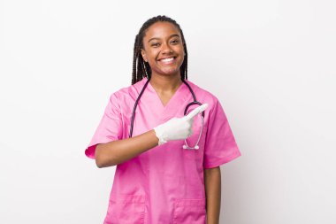 young adult black woman smiling cheerfully, feeling happy and pointing to the side. veterinarian concept
