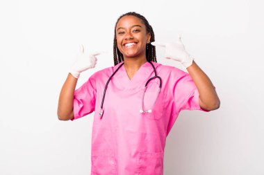 young adult black woman smiling confidently pointing to own broad smile. veterinarian concept
