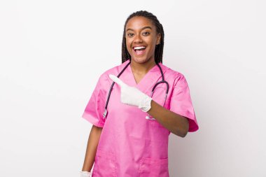 young adult black woman looking excited and surprised pointing to the side. veterinarian concept