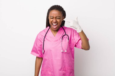young adult black woman looking unhappy and stressed, suicide gesture making gun sign. veterinarian concept