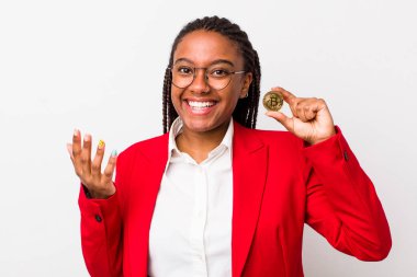 young adult black woman feeling happy, surprised realizing a solution or idea. crypto coin concept