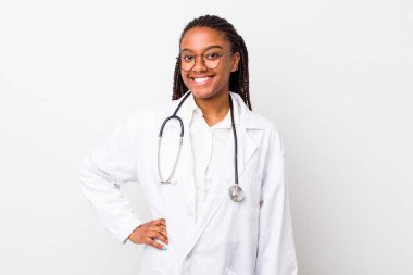 young adult black woman smiling happily with a hand on hip and confident. physician concept