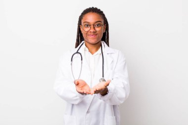 young adult black woman smiling happily with friendly and  offering and showing a concept. physician concept
