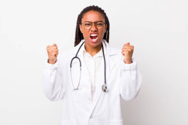 Genç, yetişkin, siyah bir kadın kızgın bir ifadeyle agresif bir şekilde bağırıyor. hekimlik kavramı