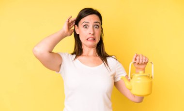 Genç ve güzel bir kadın stresli, endişeli ya da korkmuş hissediyor, elleri başının üstünde. Sıcak kahve ya da çay konsepti