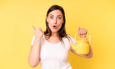 Genç ve güzel bir kadın inançsızlıktan şaşkın şaşkın bakıyor. Sıcak kahve ya da çay konsepti