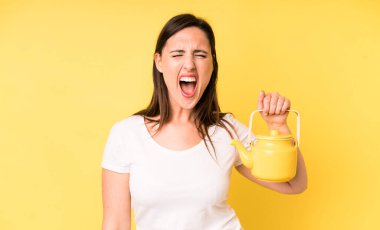 Genç ve güzel bir kadın sinirli bir şekilde bağırıyor. Sıcak kahve ya da çay konsepti