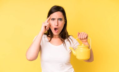 Genç ve güzel bir kadın şaşırmış görünüyor, yeni bir düşünce, fikir ya da konsept fark ediyor. Sıcak kahve ya da çay konsepti