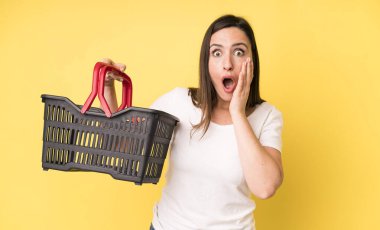 Genç ve güzel bir kadın şok olmuş ve korkmuş hissediyor. Alışveriş sepeti konsepti