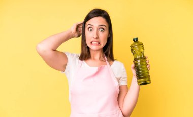 Genç ve güzel bir kadın stresli, endişeli ya da korkmuş hissediyor, elleri başının üstünde. Zeytinyağlı ev aşçısı