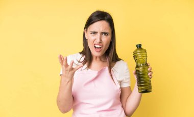 Genç ve güzel bir kadın sinirli, sinirli ve hayal kırıklığına uğramış görünüyor. Zeytinyağlı ev aşçısı